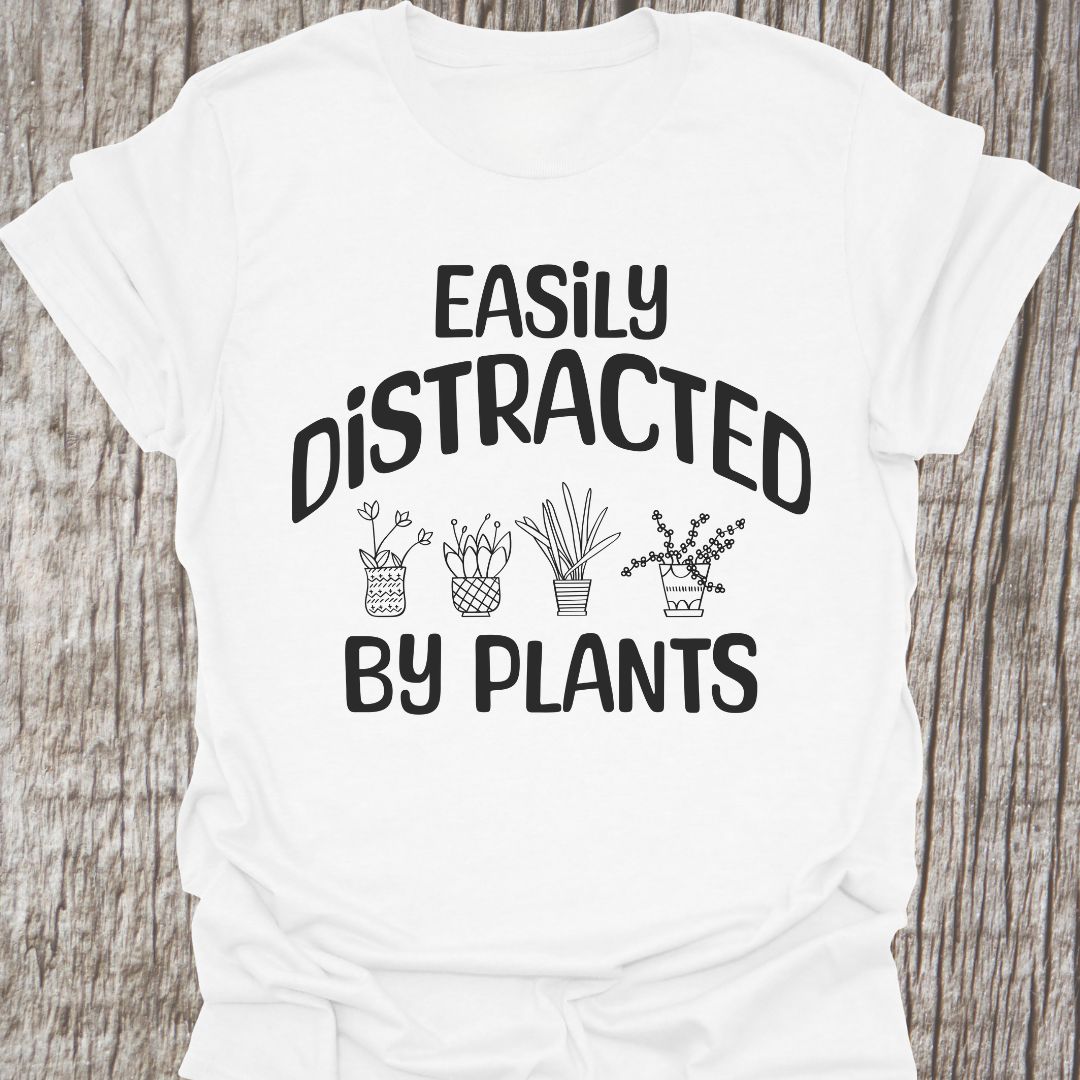 Easily Distracted By Plants in blackText with image of four small pot plants, all in black. This is on a white T-shirt