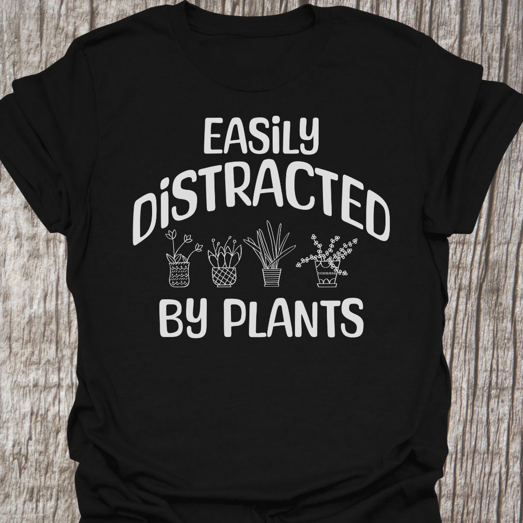 Easily Distracted By Plants in white Text with image of four small pot plants, all in white. This is on a black t-shirt