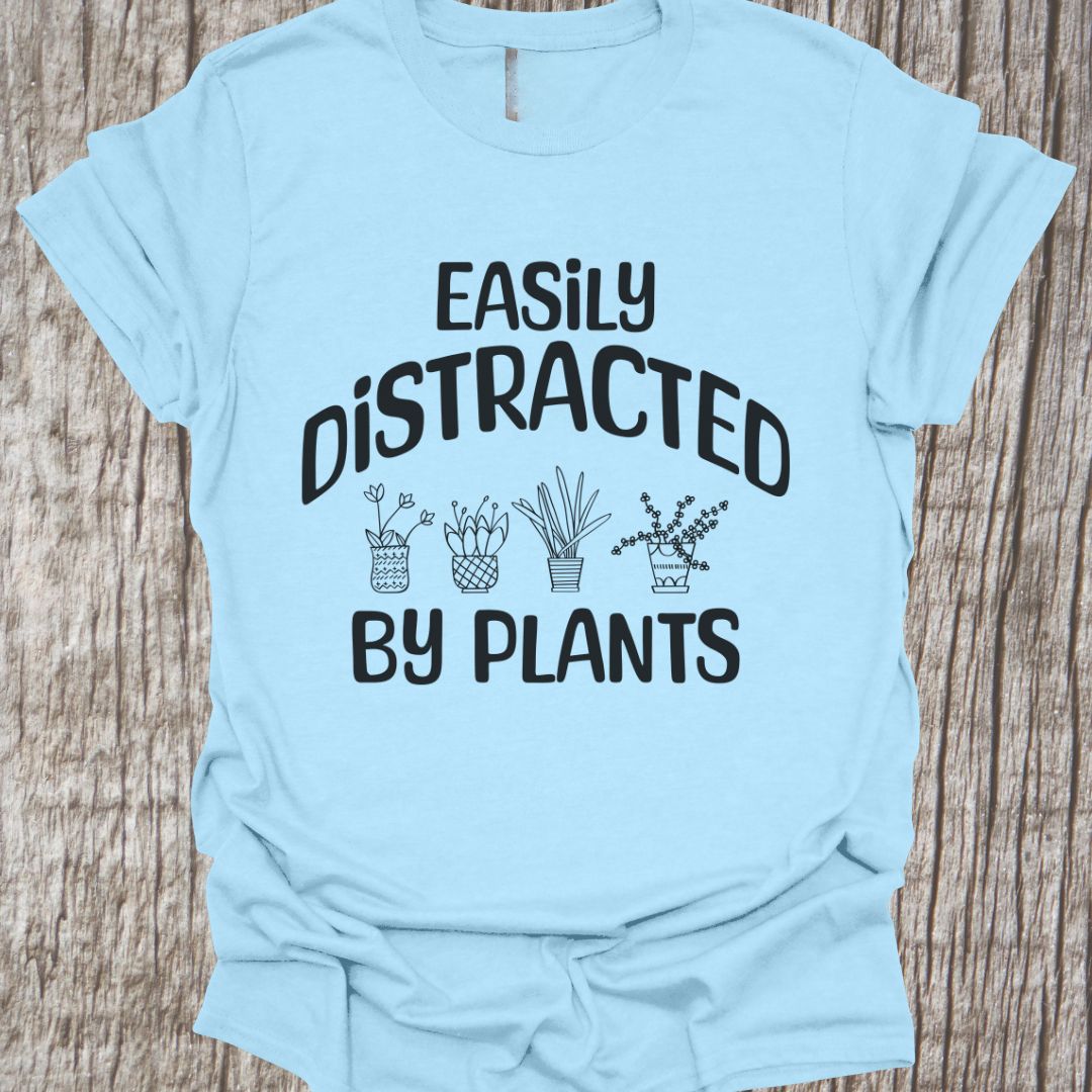 Easily Distracted By Plants in black Text with image of four small pot plants, all in black. This is on a navy blue T-shirt