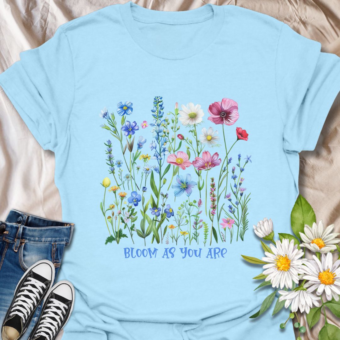 Empowering floral t-shirt featuring a vibrant wildflower garden and the phrase 'Bloom as you are.' A nature-positive, uplifting design for flower lovers, gardeners, and anyone who appreciates self-growth and beauty in every stage. Ideal for gifting or everyday wear with heart