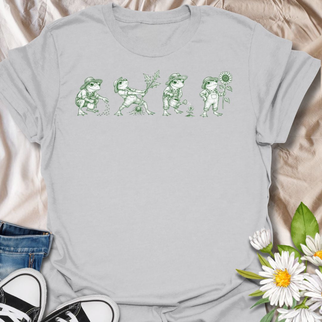 This Gardening Frogs t-shirt is made for plant lovers, gardeners, and frog fans who enjoy a whimsical nature-inspired design. Featuring four charming frogs doing garden tasks in a vintage green ink illustration style, this design has a playful cottagecore feel with plenty of botanical personality. Perfect for gardeners, plant moms, frog lovers, nature fans, cottagecore style lovers, and anyone who thinks gardening is better with a little amphibian charm.