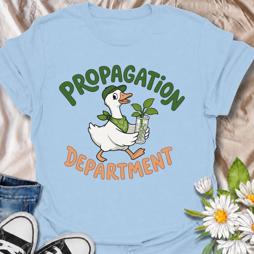 A funny propagation T-shirt for plant lovers who treat rooting cuttings like a proper department of operations. Featuring a cheerful goose carrying a fresh plant cutting in water, this design is perfect for houseplant collectors, plant parents, and propagation fans. The “Propagation Department” phrase gives the design a playful club-style feel without losing its clean, easy-to-read look. It makes a great gift for pothos lovers, indoor gardeners, and anyone with jars of cuttings taking over the counter. Idea