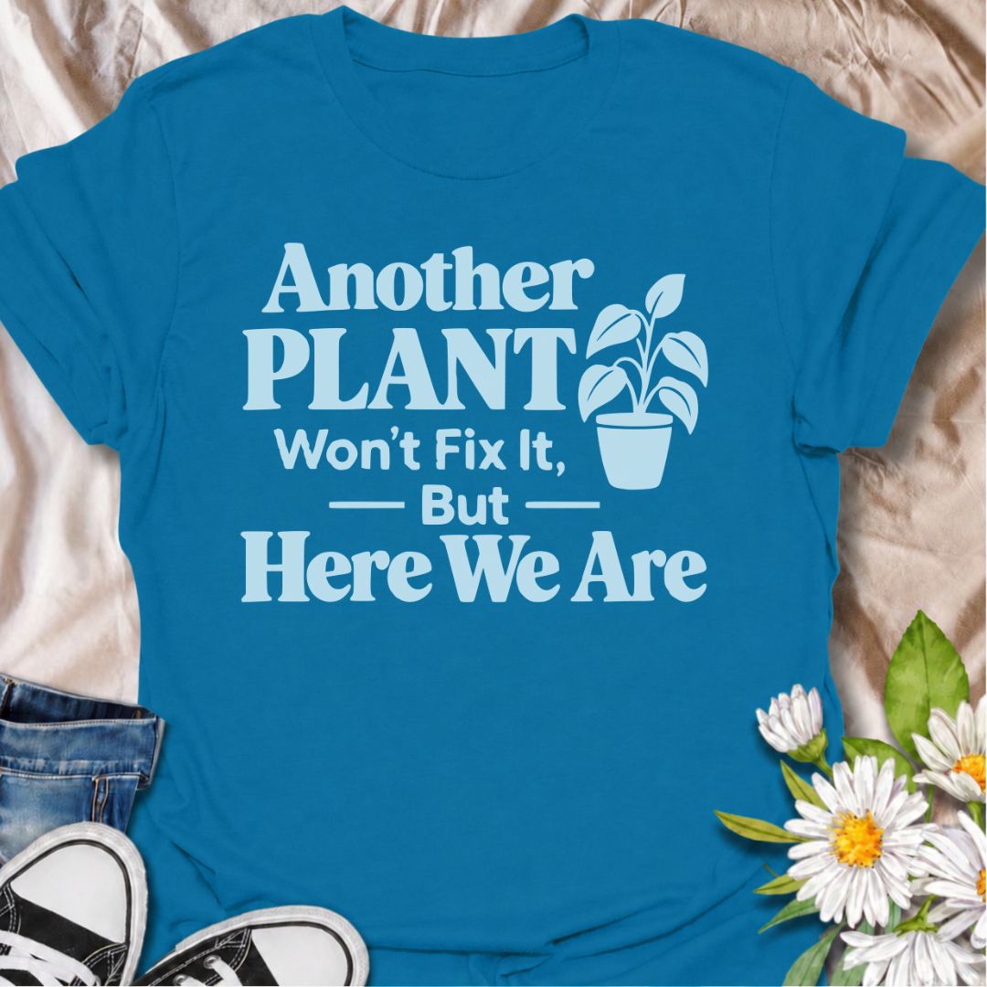 A funny plant T-shirt for anyone who knows buying another houseplant probably will not solve the problem—but does it anyway. The phrase “Another Plant Won’t Fix It, But Here We Are” delivers dry, self-aware humor that plant parents and collectors will instantly understand. Featuring bold typography with a simple potted plant graphic, the design stays clean, readable, and easy to wear. It makes a great gift for houseplant lovers, nursery regulars, and anyone whose indoor jungle keeps growing despite their be
