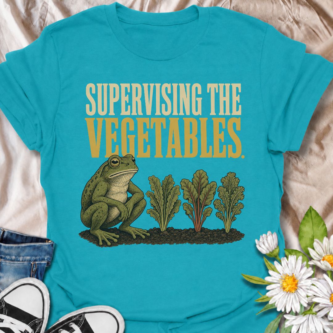 A funny gardening T-shirt for anyone who spends nearly as much time watching the vegetable patch as working in it. Featuring a deadpan frog keeping a close eye on a neat row of leafy greens, the phrase “Supervising the Vegetables” delivers dry, character-led garden humor. It is perfect for vegetable gardeners, backyard growers, allotment lovers, and anyone who checks on their crops several times a day. The vintage-style illustration gives the design plenty of personality while still keeping it easy to wear.