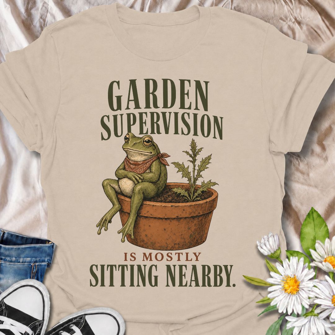 A funny gardening T-shirt for anyone who knows that supervising the garden often means sitting nearby and keeping an eye on things. The phrase “Garden Supervision Is Mostly Sitting Nearby” pairs perfectly with a deadpan frog perched beside a potted weed for dry, character-led garden humor. It is ideal for backyard gardeners, plant lovers, frog fans, and anyone who spends plenty of time simply observing what is growing. The vintage-style illustration gives the design personality while keeping it easy to wear