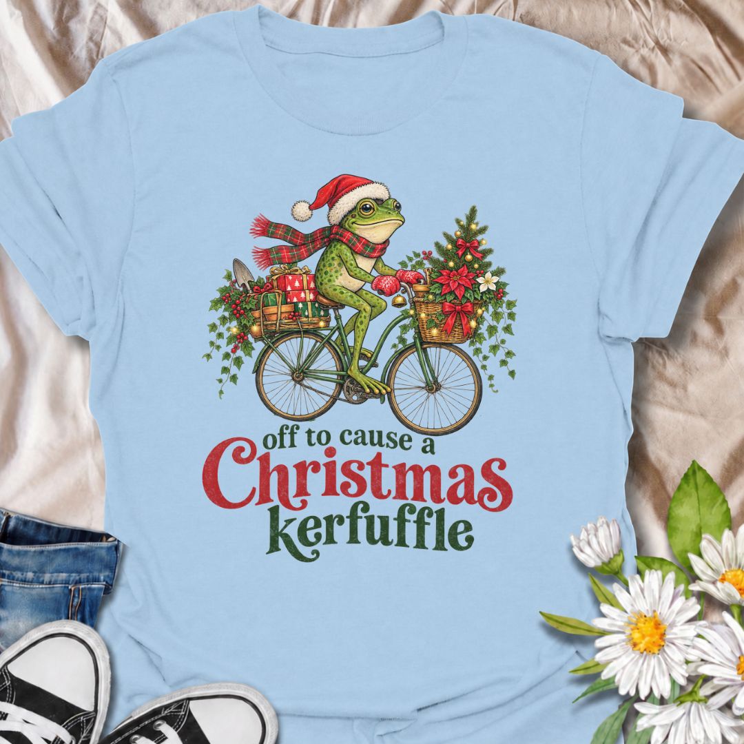 A funny Christmas gardening T-shirt featuring a determined frog cycling off to cause a little festive trouble. The phrase “Off to Cause a Christmas Kerfuffle” combines Botanic Weave’s deadpan frog humor with holly, gifts, garden tools, and plenty of Christmas cheer. It is perfect for gardeners, frog lovers, plant people, and anyone who prefers their holiday shirts funny rather than overly sweet. The detailed vintage-style illustration gives it a festive storybook feel while keeping the joke front and center