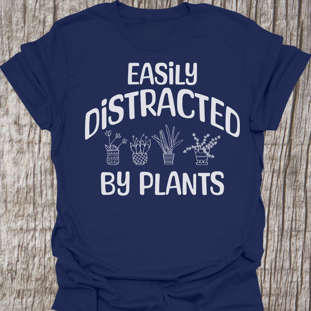 Easily Distracted By Plants in white Text with image of four small pot plants, all in white. This is on a navy blue T-shirt