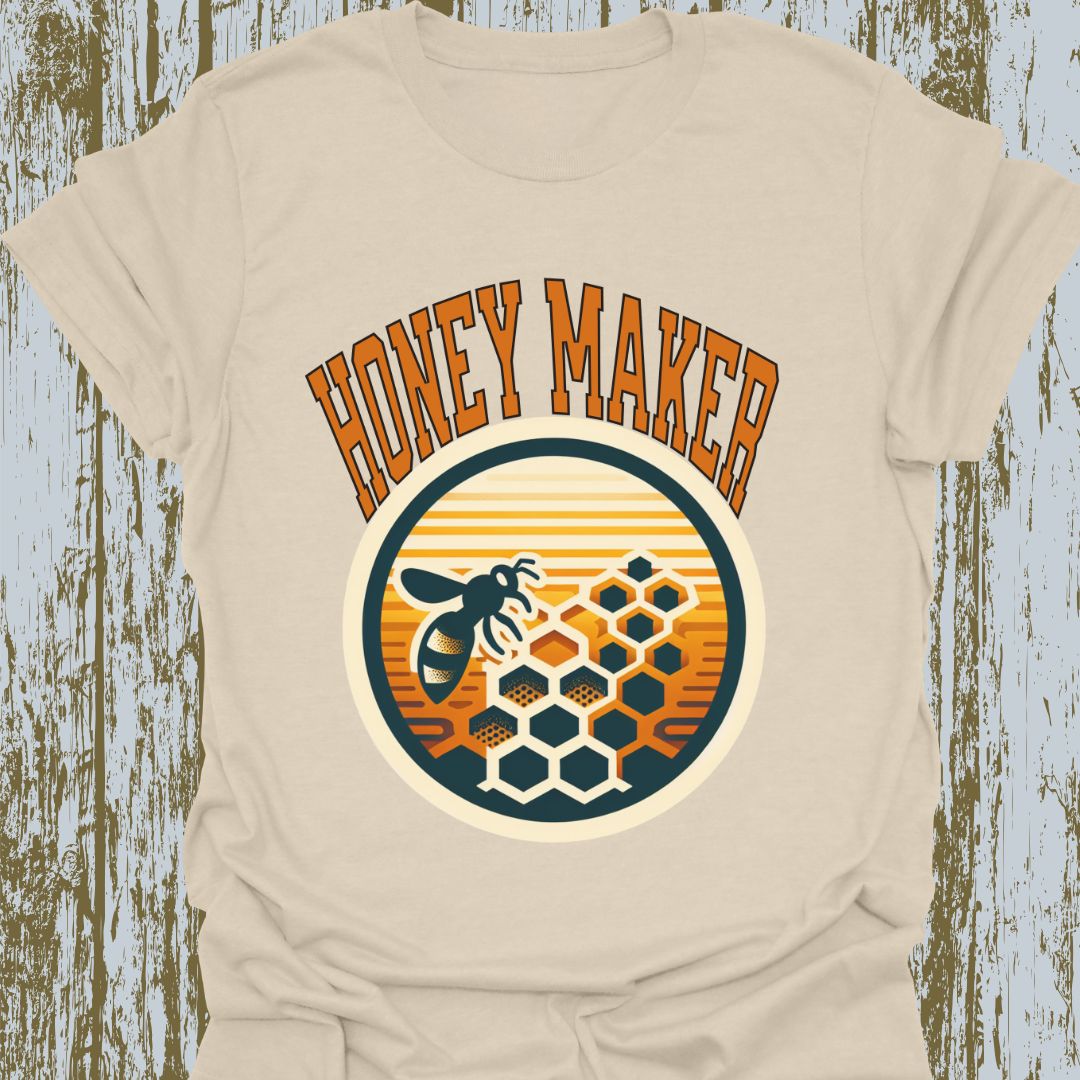 Natural T-shirt featuring a circular design with a bee and honeycomb, accompanied by the text "Honey Maker" in orange.