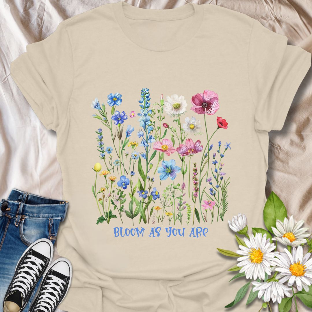 Empowering floral t-shirt featuring a vibrant wildflower garden and the phrase 'Bloom as you are.' A nature-positive, uplifting design for flower lovers, gardeners, and anyone who appreciates self-growth and beauty in every stage. Ideal for gifting or everyday wear with heart