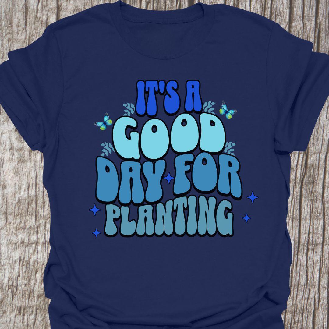 It's a good day for planting written in various shades of blue text with small stars and buterflies decorating it, on a navy blue t-shirt