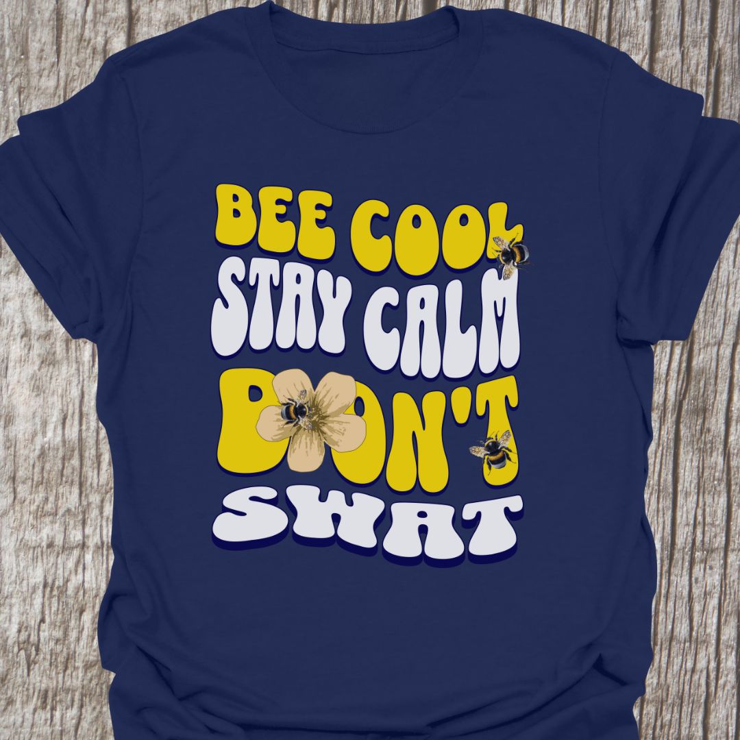 "Bee Cool, Stay Calm, Don't Swat" shaped text in white and yellow with images of bees and flowers. Navy colored T-shirt