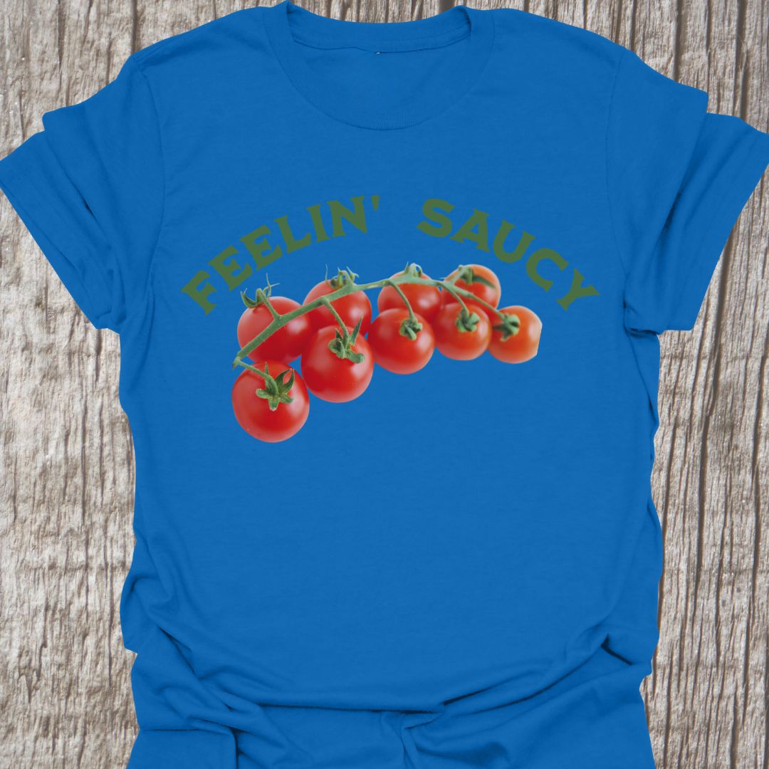 Feelin' Saucy Text written in an arch over image of tomatoes on the vine on a royal blue t-shirt