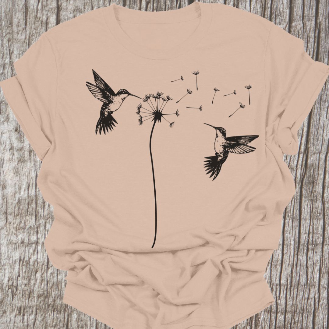 Two humming birds hovering at Dandelion in black on sand t-shirt