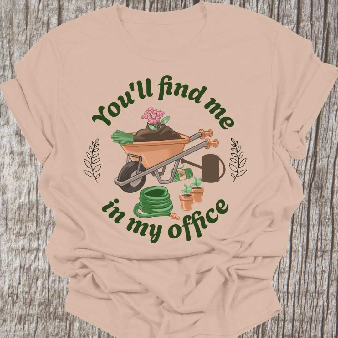 circular text 'You'll find me in my office' with wheelbarrow, hose, plants and watering can within circle all text in green on sand t-shirt