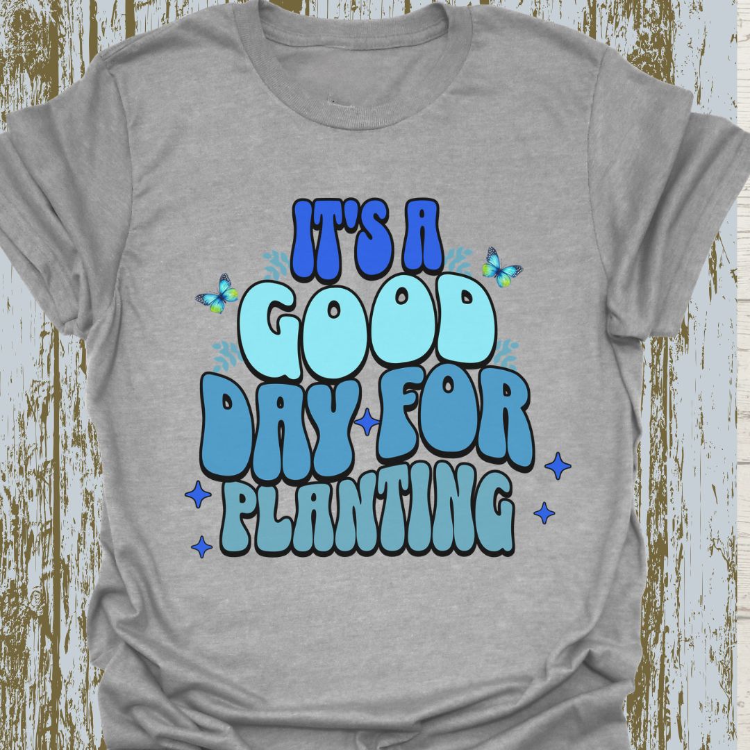 It's a good day for planting written in various shades of blue text with small stars and buterflies decorating it, on a sport grey t-shirt