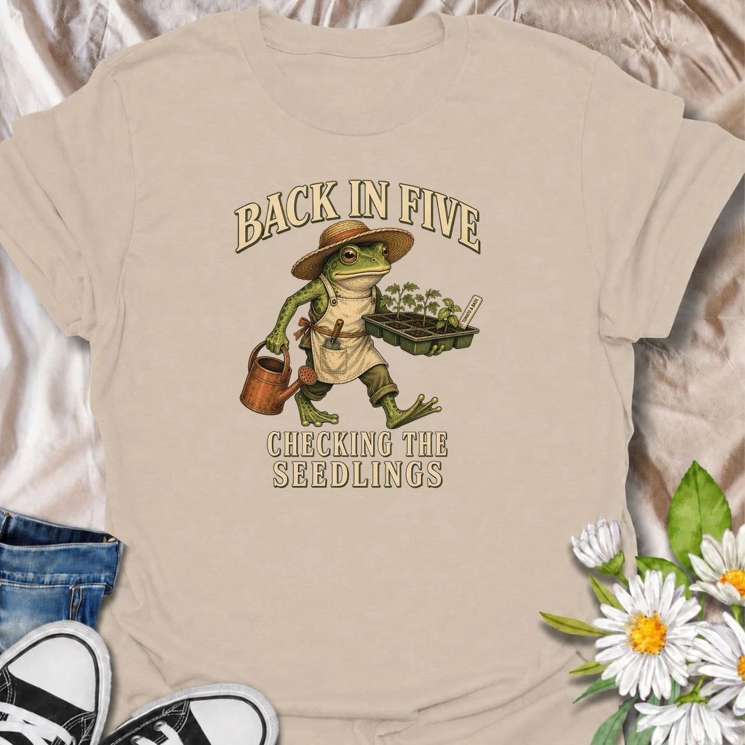 Funny gardening T-shirt for plant lovers who are always disappearing to check seedlings, water pots or inspect the garden. Features a vintage frog gardener illustration and playful “Back in Five, Checking the Seedlings” design for gardeners, growers and houseplant fans.