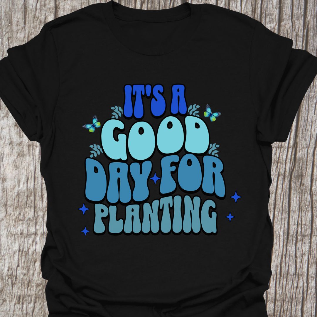 It's a good day for planting written in various shades of blue text with small stars and buterflies decorating it, on a black t-shirt