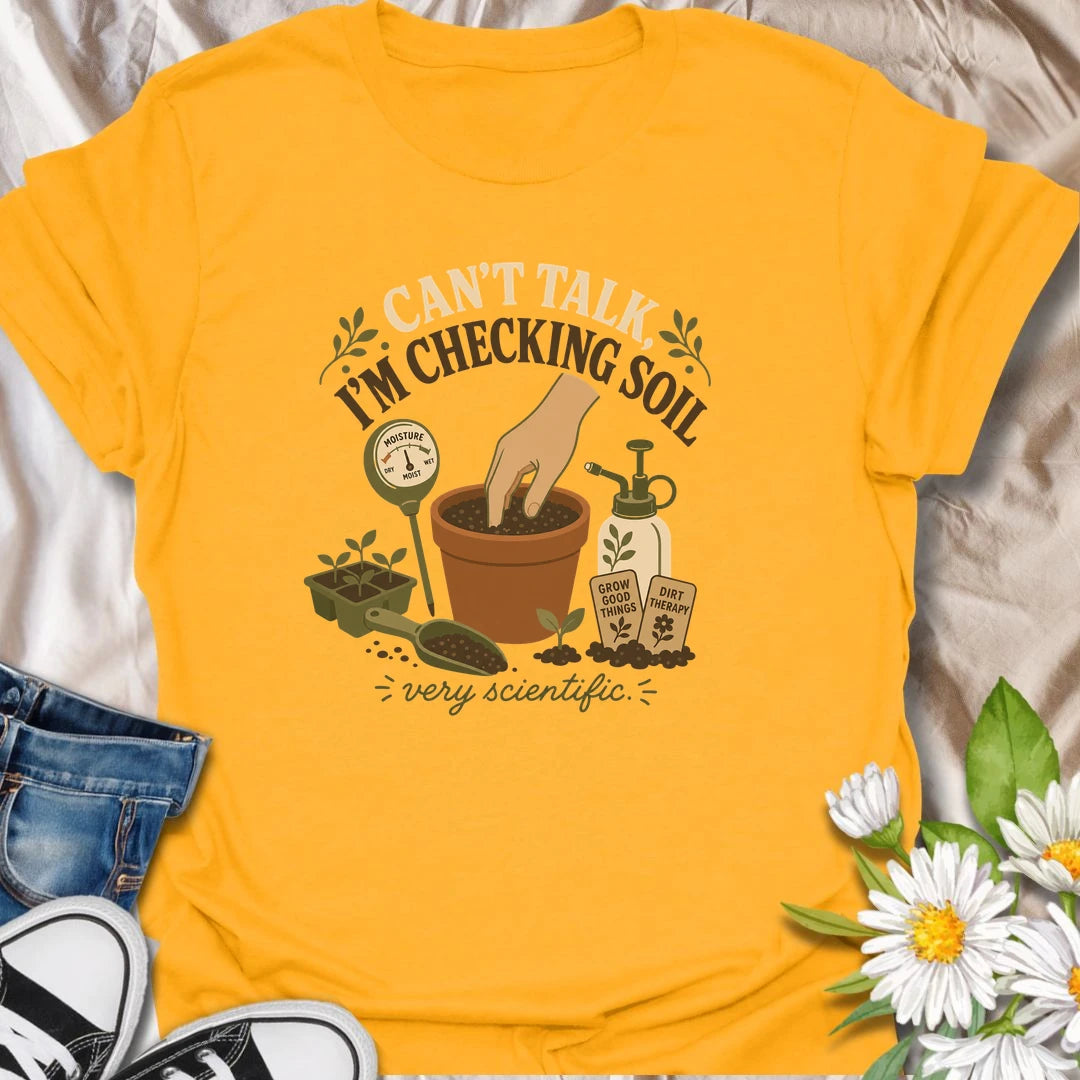 A humorous gardening T-shirt for plant lovers who take soil checks very seriously. The design features a terracotta pot, moisture meter, seedlings, mister, and gardening accessories. A fun gift for houseplant owners, gardeners, and anyone regularly caught testing their potting soil.