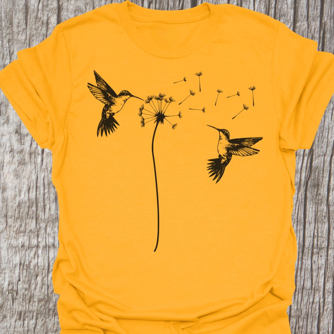 Two humming birds hovering at Dandelion in black on gold t-shirt