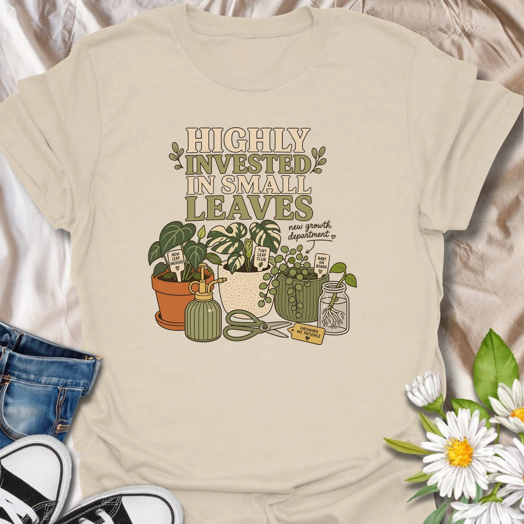 A playful plant lover T-shirt celebrating the excitement of every tiny new leaf. The design features houseplants, propagation cuttings, pruning shears, a mister, and cheerful plant markers. A thoughtful gift for plant moms, propagation enthusiasts, and anyone carefully watching for new growth.