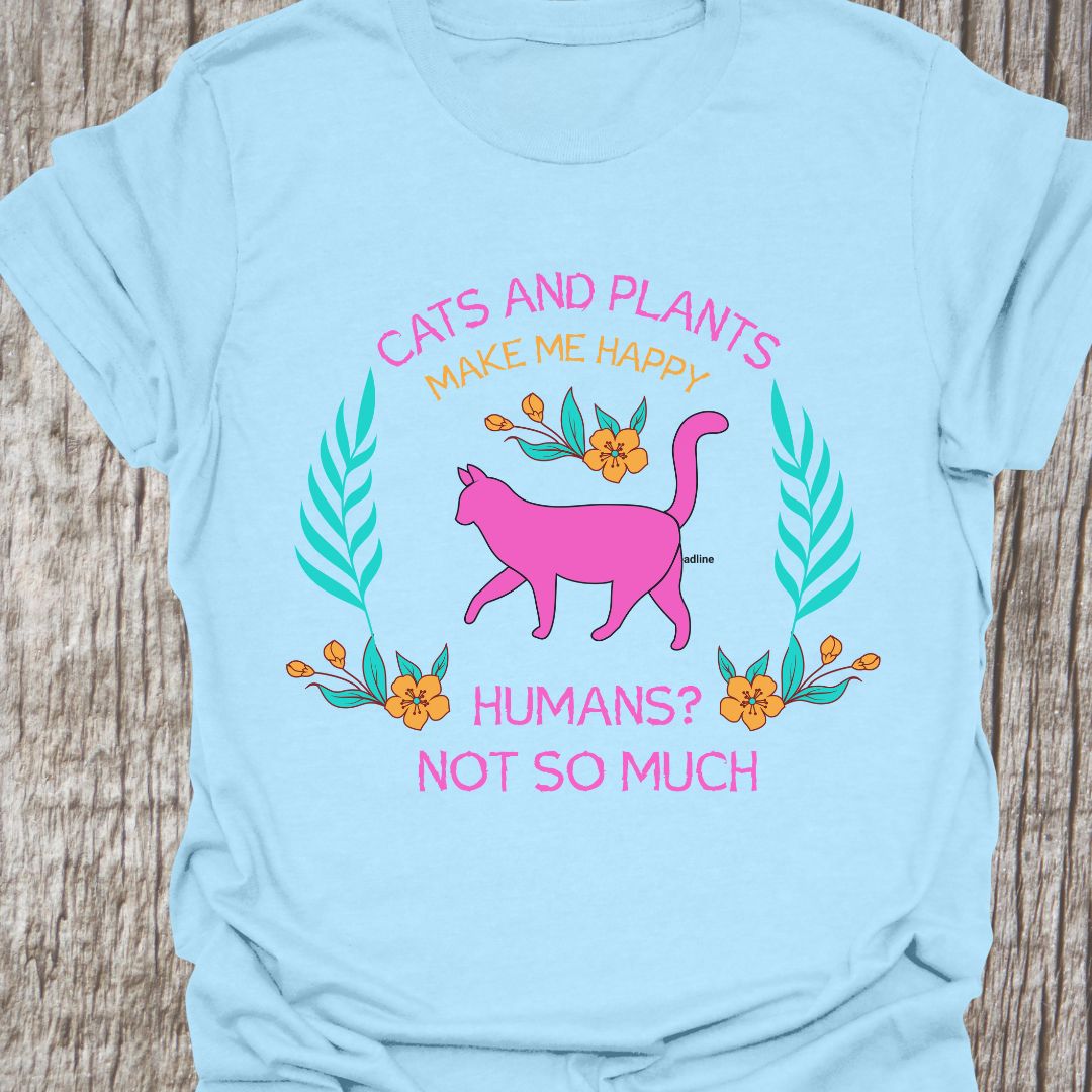 Cat and Plants Make Me Happy, Humans? Not So Much text and image design with pink cat as main image and decorative leaves, and flowers. Light blue t-shirt