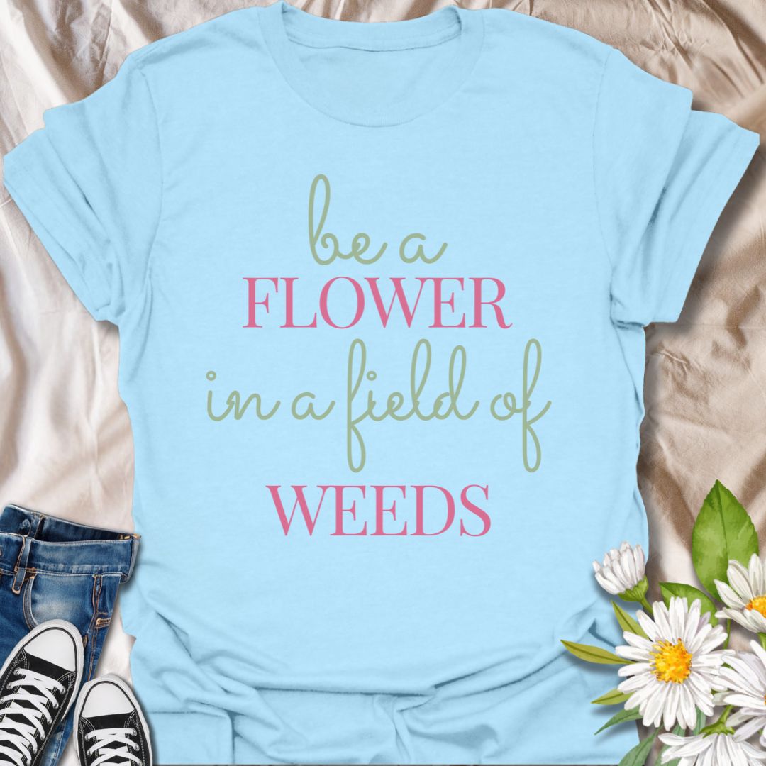 Stand out with this inspirational graphic t-shirt featuring the motivational phrase "Be a Flower in a Field of Weeds." Perfect for positivity seekers, nature lovers, and anyone who enjoys uplifting, floral-themed apparel with a meaningful message.