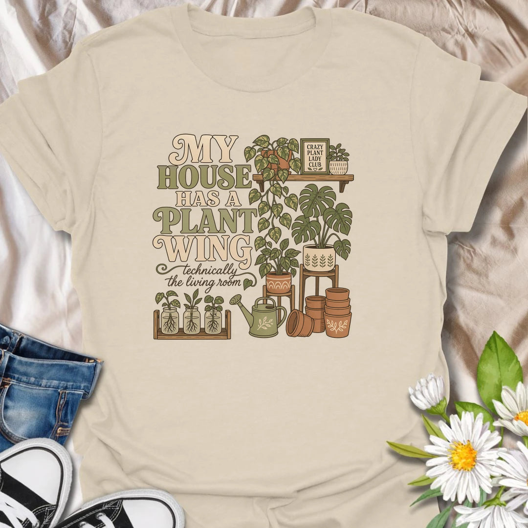 A funny houseplant T-shirt for anyone whose living room has gradually become a dedicated indoor garden. The design features overflowing plant shelves, propagation jars, watering supplies, and stacks of terracotta pots. A charming gift for indoor gardeners, plant moms, and collectors with greenery in every room.