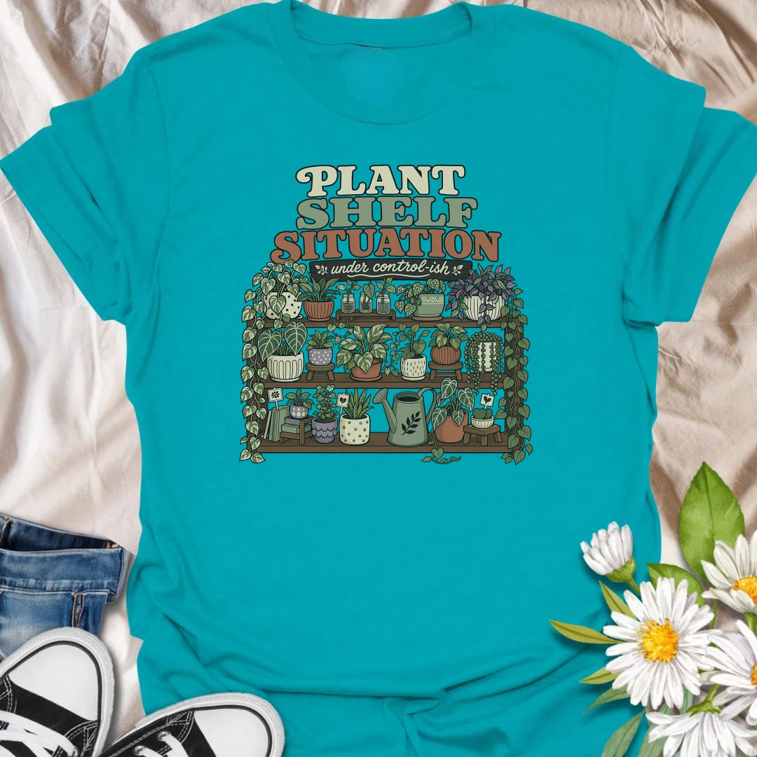 Celebrate a gloriously crowded indoor jungle with this funny “Plant Shelf Situation” T-shirt. Featuring shelves packed with trailing houseplants, decorative pots, propagation jars, and a watering can, it perfectly captures a collection that is only “under control-ish.” A fun gift for plant moms, houseplant collectors, and anyone who always finds room for one more plant.