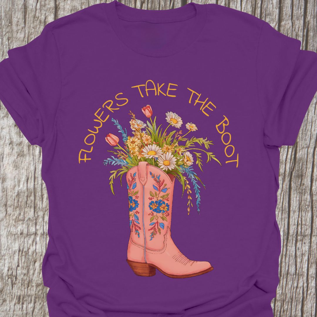 Flowers Take The Boot - Purple t-shirt featuring a pink boot with flowers emerging from it. The boot also has a floral design.