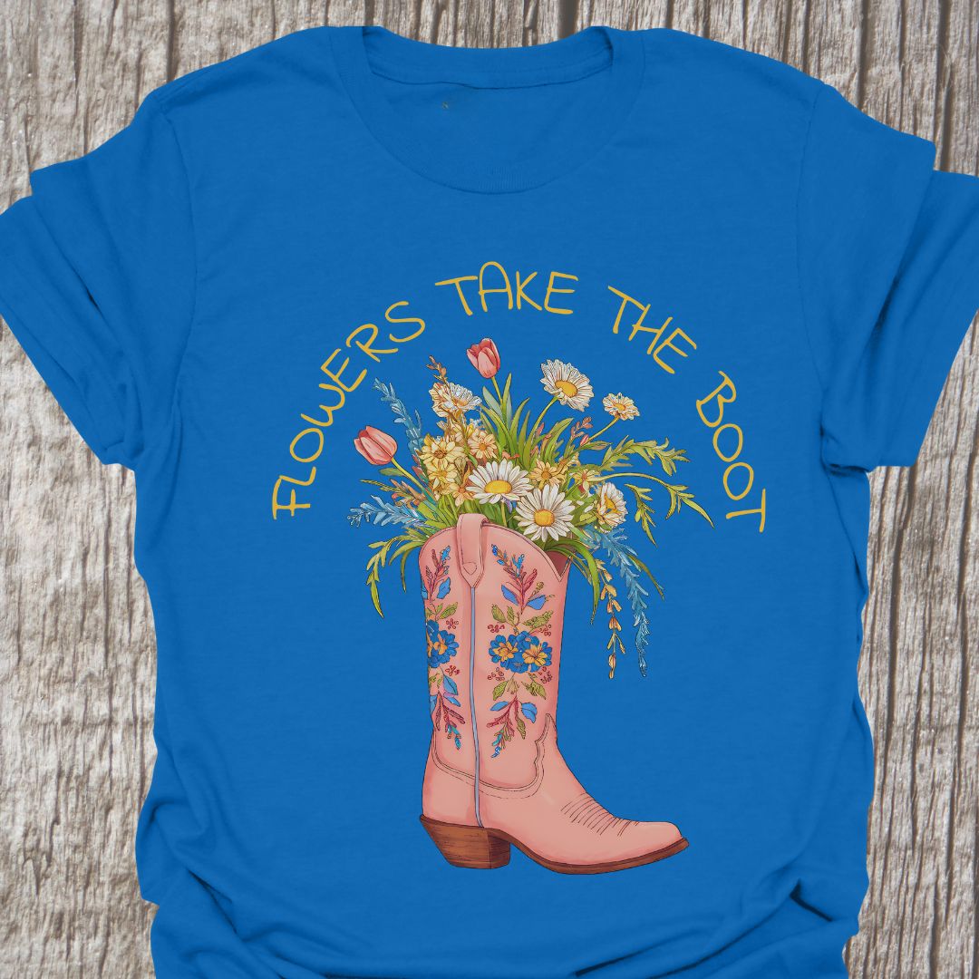 Flowers Take The Boot - Royal Blue t-shirt featuring a pink boot with flowers emerging from it. The boot also has a floral design.