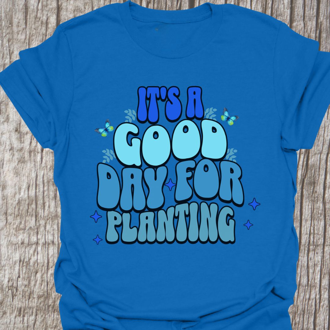 It's a good day for planting written in various shades of blue text with small stars and buterflies decorating it, on a royal blue t-shirt