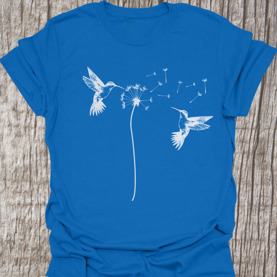 Two humming birds hovering at Dandelion in white on royal blue t-shirt