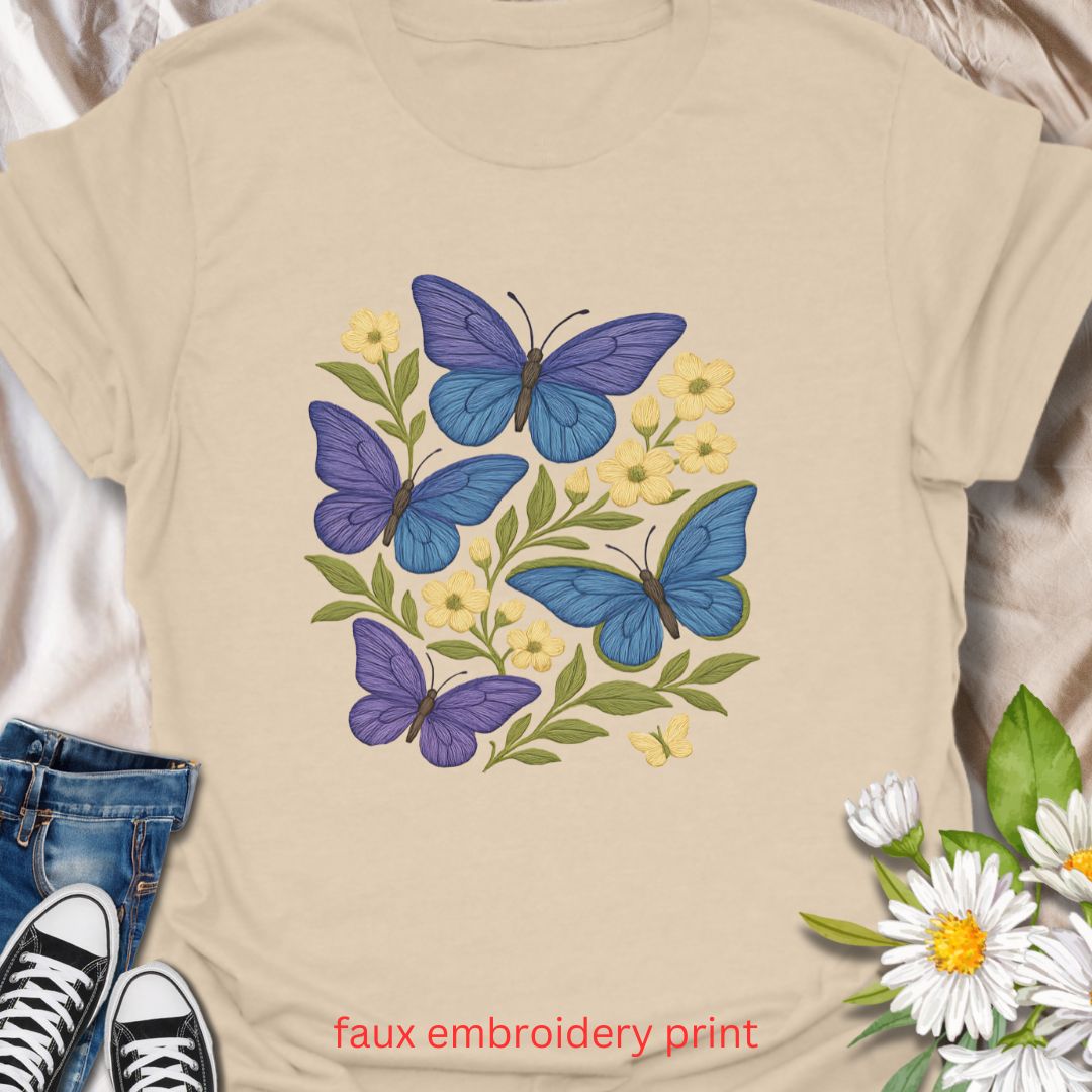 Bring whimsical garden vibes to your wardrobe with this faux embroidery butterfly and floral t-shirt. Featuring vibrant blue and purple butterflies among soft yellow flowers, this nature-inspired design mimics stitched embroidery for a cozy, handmade look—without the thread. Perfect for lovers of cottagecore fashion, pollinator gardens, and floral aesthetics.