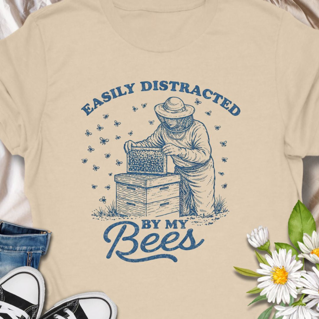 Show off your hive obsession with this “Easily Distracted By My Bees” t-shirt, featuring a vintage-style beekeeper and buzzing bees. Perfect gift for apiarists, backyard beekeepers, and bee lovers who’d rather be checking their hives than anything else.