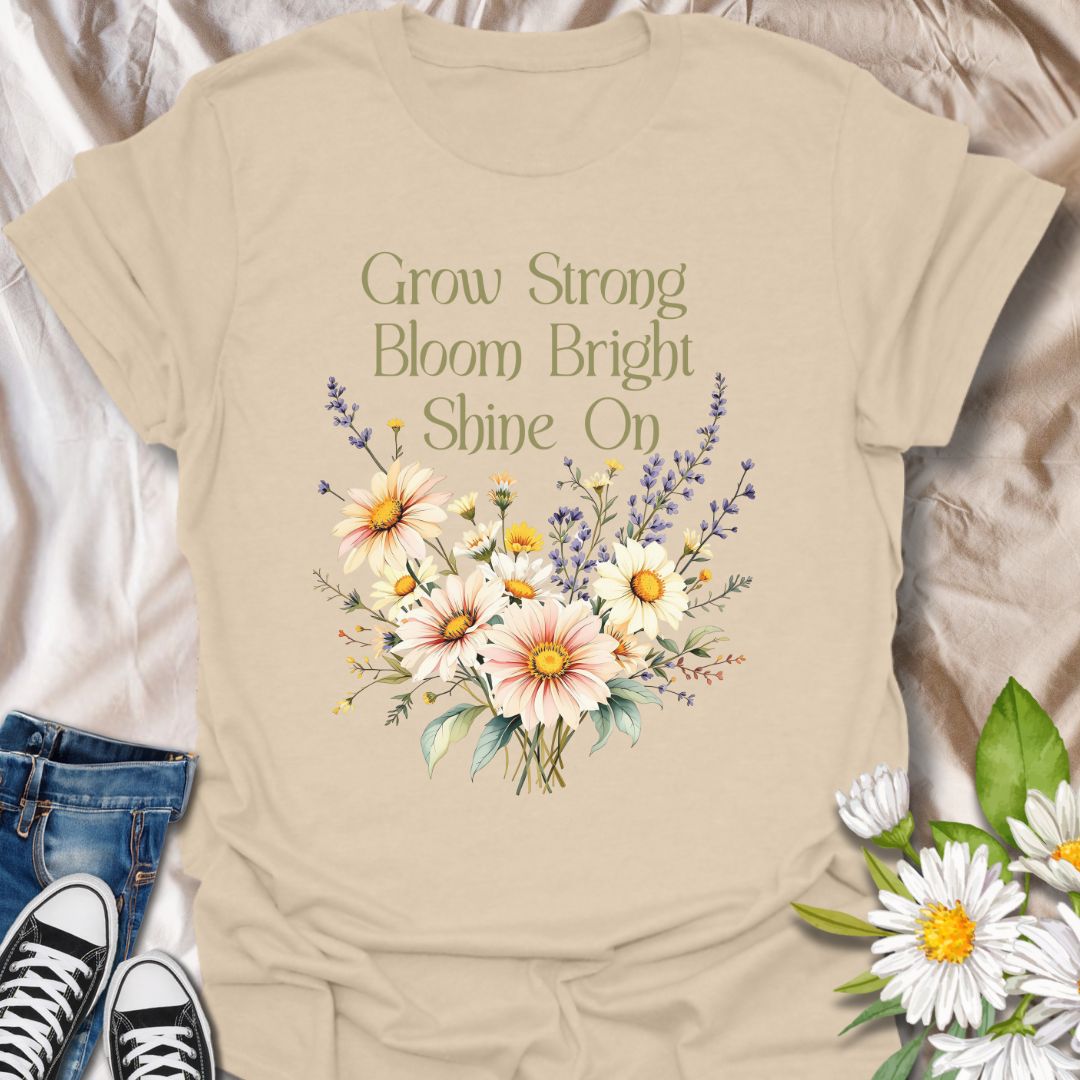 Embrace positivity and growth with this beautifully designed floral t-shirt featuring the empowering phrase "Grow Strong, Bloom Bright, Shine On". This tee has a vibrant bouquet of daisies and wildflowers, this inspirational tee is perfect for nature lovers, garden enthusiasts, teachers, or anyone who believes in blooming through life’s seasons. A thoughtful gift for those who radiate light and strength.