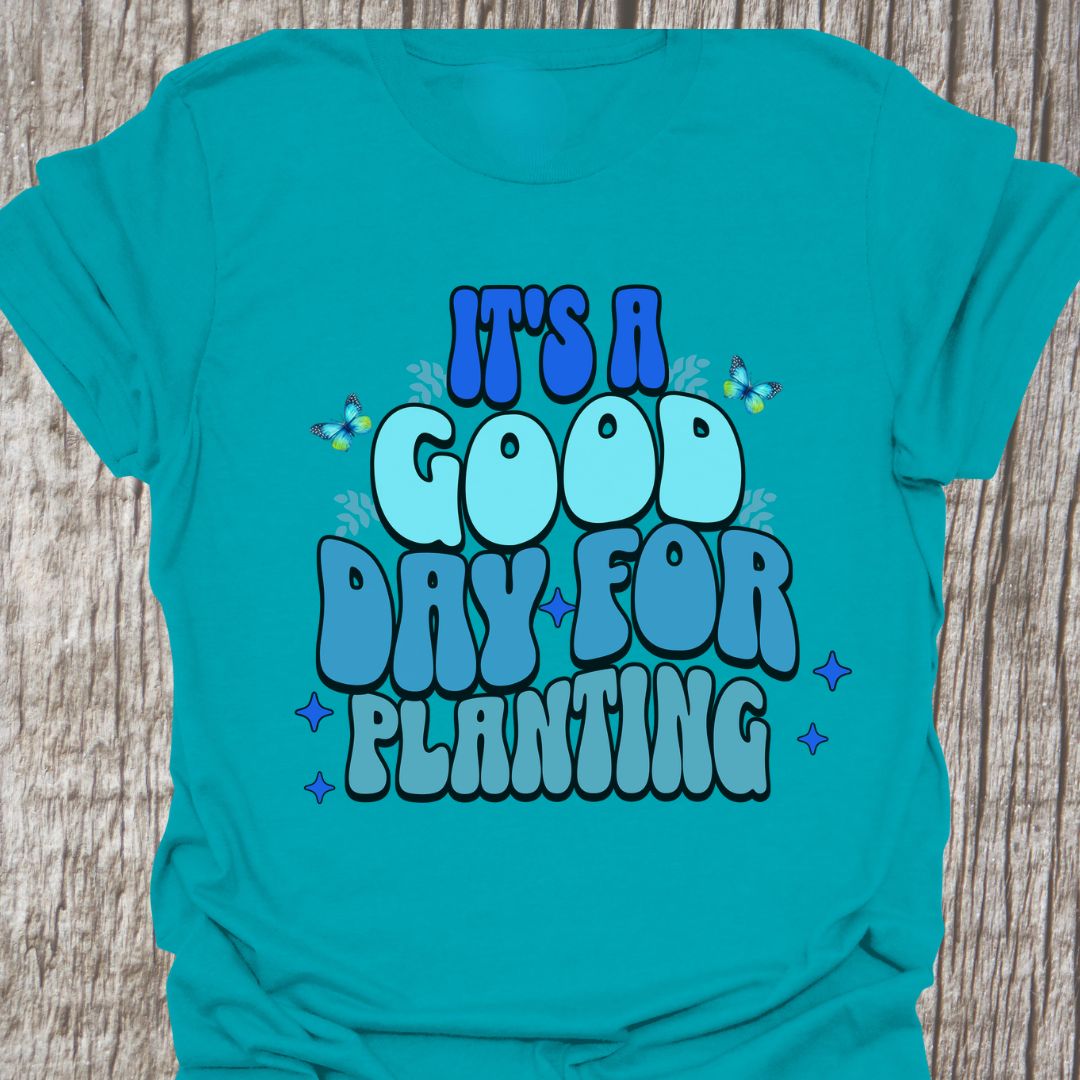 It's a good day for planting written in various shades of blue text with small stars and buterflies decorating it, on a tropical blue t-shirt