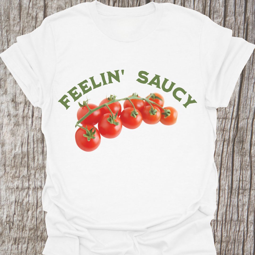 Feelin' Saucy Text written in an arch over image of tomatoes on the vine on a white t-shirt