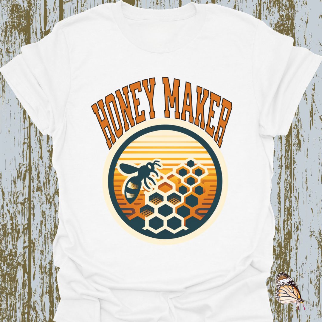 White T-shirt featuring a circular design with a bee and honeycomb, accompanied by the text "Honey Maker" in orange.