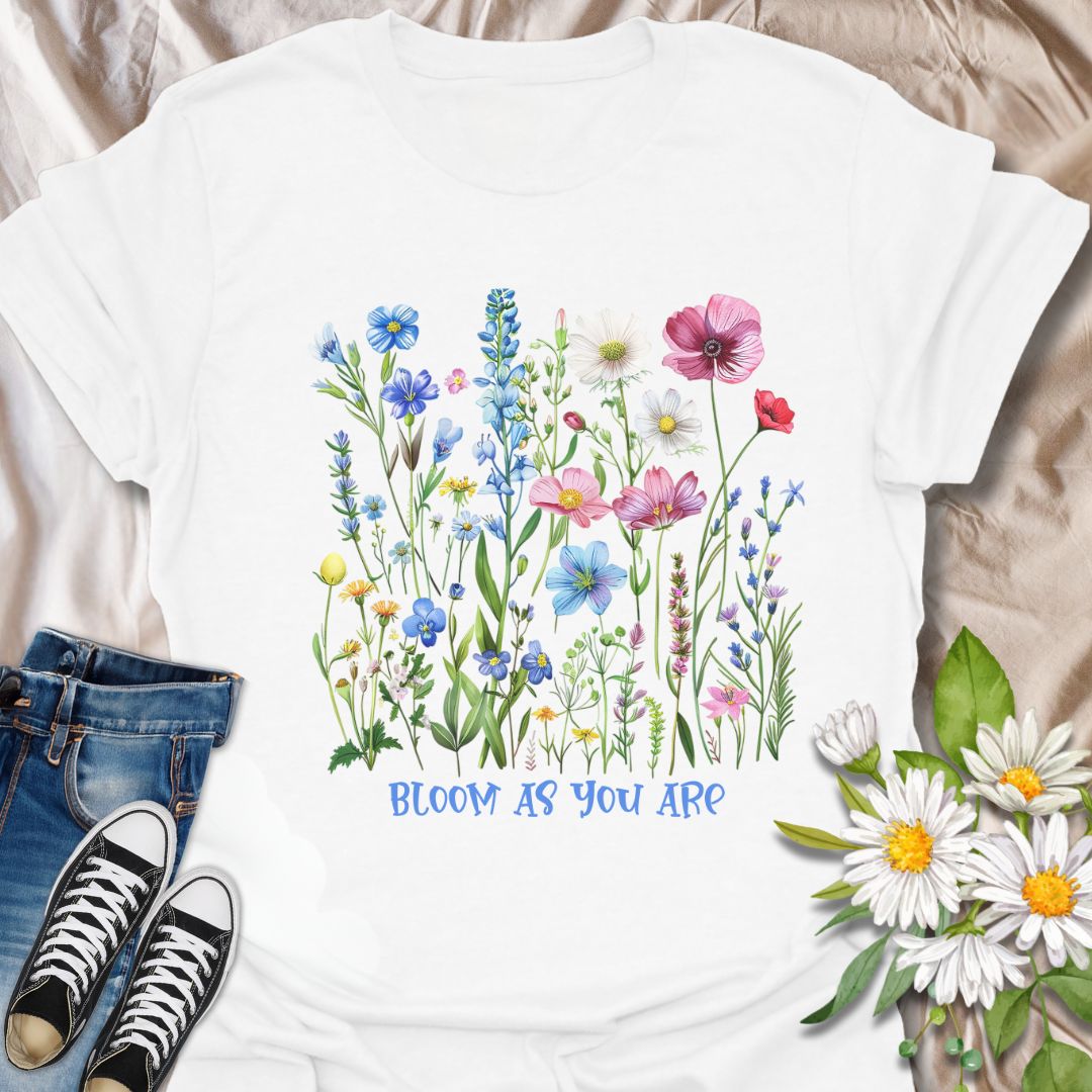 Empowering floral t-shirt featuring a vibrant wildflower garden and the phrase 'Bloom as you are.' A nature-positive, uplifting design for flower lovers, gardeners, and anyone who appreciates self-growth and beauty in every stage. Ideal for gifting or everyday wear with heart