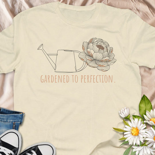 Celebrate your love of gardening with this “Gardened to Perfection” t-shirt featuring a delicate watering can and floral illustration. A beautiful botanical tee for flower lovers, plant moms, and cottagecore garden enthusiasts.