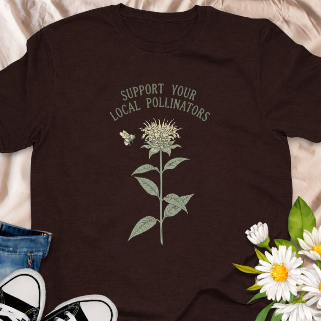 Show your love for bees and pollinator-friendly gardens with this “Support Your Local Pollinators” t-shirt. Featuring a botanical flower and bee illustration, this nature-inspired tee is perfect for gardeners, wildflower enthusiasts, and anyone passionate about helping pollinators thrive. A thoughtful gift for plant lovers and eco-conscious gardeners.