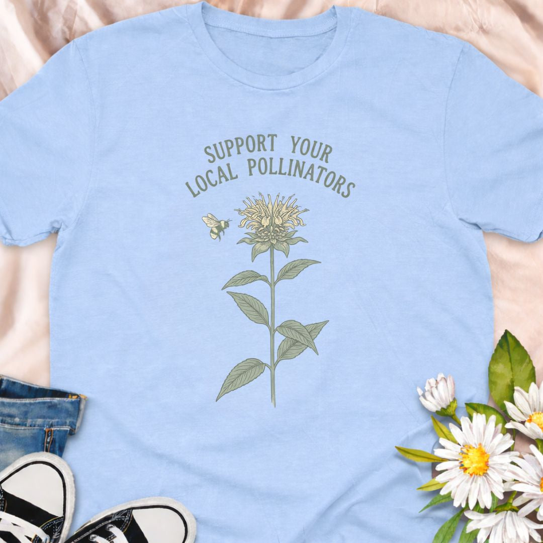 Show your love for bees and pollinator-friendly gardens with this “Support Your Local Pollinators” t-shirt. Featuring a botanical flower and bee illustration, this nature-inspired tee is perfect for gardeners, wildflower enthusiasts, and anyone passionate about helping pollinators thrive. A thoughtful gift for plant lovers and eco-conscious gardeners.