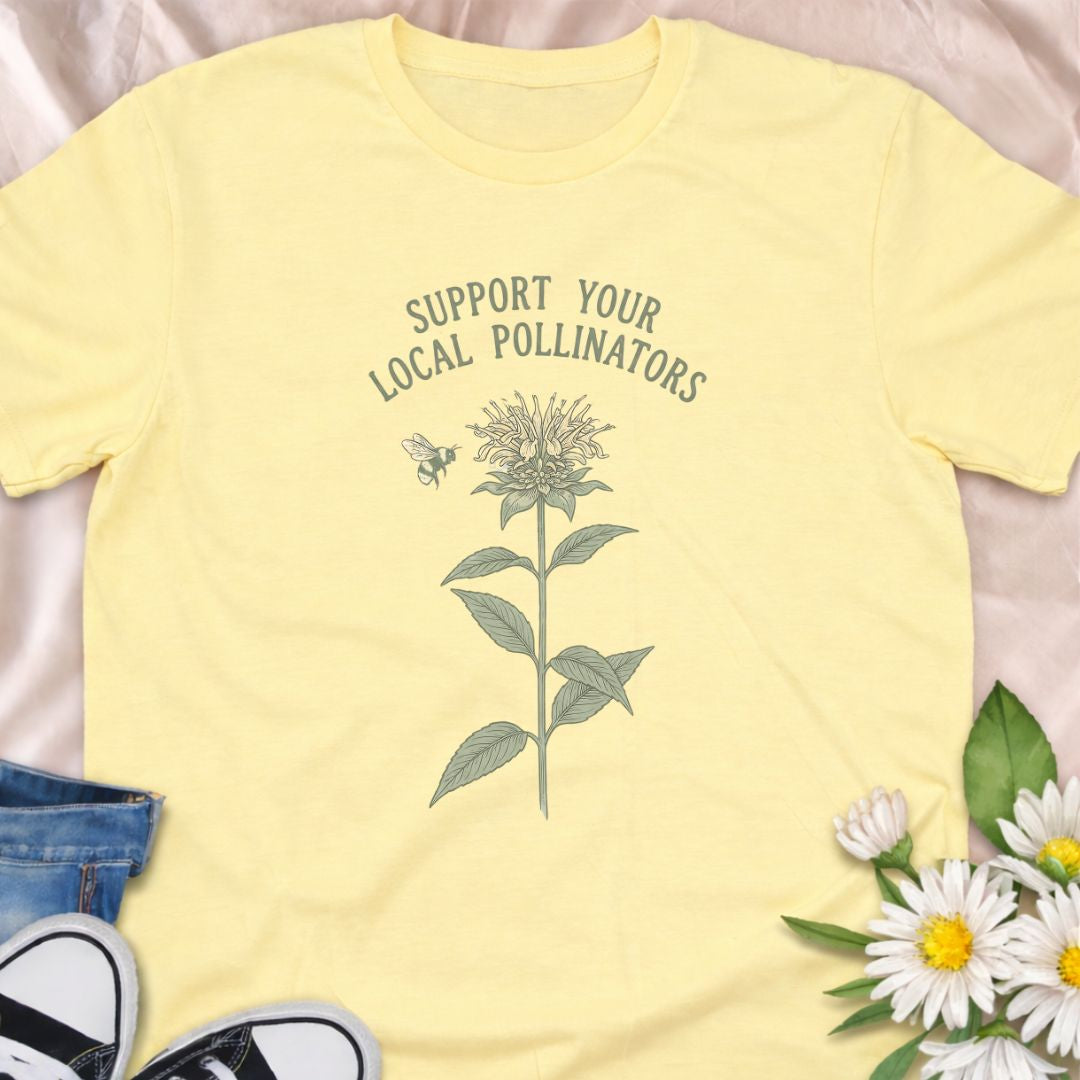 Show your love for bees and pollinator-friendly gardens with this “Support Your Local Pollinators” t-shirt. Featuring a botanical flower and bee illustration, this nature-inspired tee is perfect for gardeners, wildflower enthusiasts, and anyone passionate about helping pollinators thrive. A thoughtful gift for plant lovers and eco-conscious gardeners.
