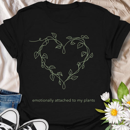 Minimalist plant lover t-shirt featuring a delicate vine heart and “emotionally attached to my plants.” Perfect for plant parents, houseplant lovers, and botanical aesthetics. A soft, nature-inspired tee ideal for everyday wear or thoughtful gifting.                      