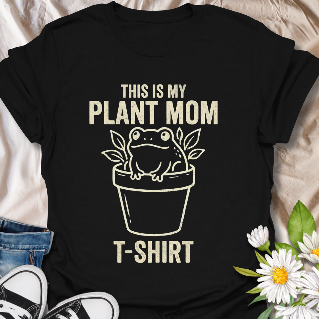 Funny plant mom t-shirt featuring a cute frog sitting in a flower pot with leafy botanical details. A playful plant lover tee for houseplant fans, indoor gardeners, and anyone proud of their plant mom era.