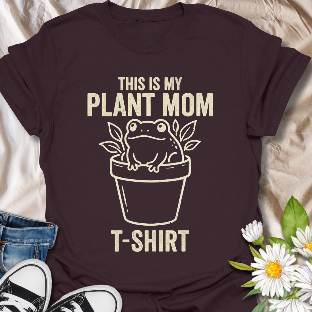 Funny plant mom t-shirt featuring a cute frog sitting in a flower pot with leafy botanical details. A playful plant lover tee for houseplant fans, indoor gardeners, and anyone proud of their plant mom era.