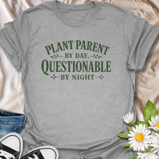 Funny plant lover t-shirt featuring the phrase “Plant Parent by Day, Questionable by Night.” A playful tee for plant parents, houseplant lovers, indoor gardeners, and anyone with a slightly mischievous sense of humor and a serious love of plants.