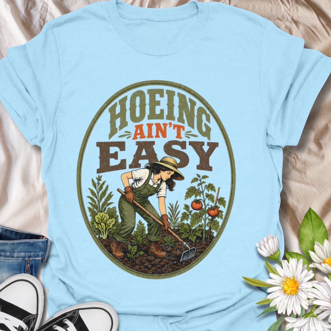 This Hoeing Ain’t Easy t-shirt is made for gardeners who know that growing tomatoes, tending soil, and keeping the garden alive takes real work. The vintage-inspired design features a gardener using a hoe among vegetables, leafy plants, tomatoes, and rich garden soil, giving it a funny but classic homestead garden feel. Perfect for backyard gardeners, vegetable growers, allotment keepers, homesteaders, tomato gardeners, plant lovers, and anyone who knows garden chores are worth it.