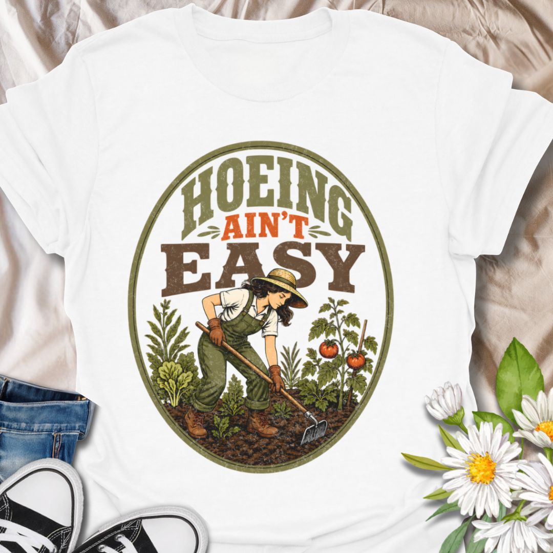 This Hoeing Ain’t Easy t-shirt is made for gardeners who know that growing tomatoes, tending soil, and keeping the garden alive takes real work. The vintage-inspired design features a gardener using a hoe among vegetables, leafy plants, tomatoes, and rich garden soil, giving it a funny but classic homestead garden feel. Perfect for backyard gardeners, vegetable growers, allotment keepers, homesteaders, tomato gardeners, plant lovers, and anyone who knows garden chores are worth it.