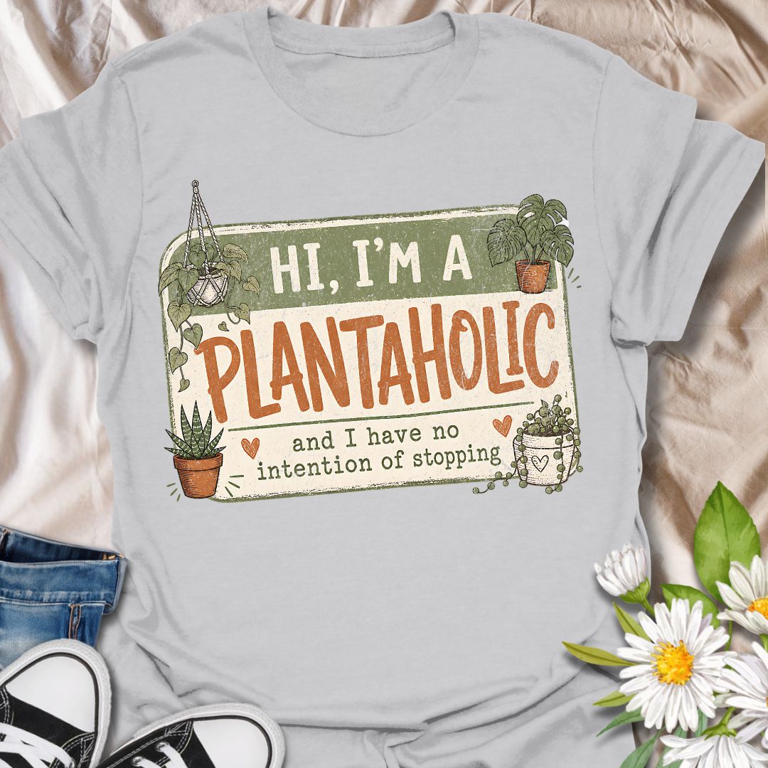 This Hi, I’m A Plantaholic t-shirt is perfect for plant lovers who can never resist one more houseplant. Featuring a playful badge-style layout with potted plants, trailing vines, and the phrase and I have no intention of stopping, this design brings a fun and relatable plant-parent vibe to any casual outfit. A great gift for plant moms, houseplant collectors, propagation fans, indoor gardeners, and anyone proudly obsessed with their growing plant collection.